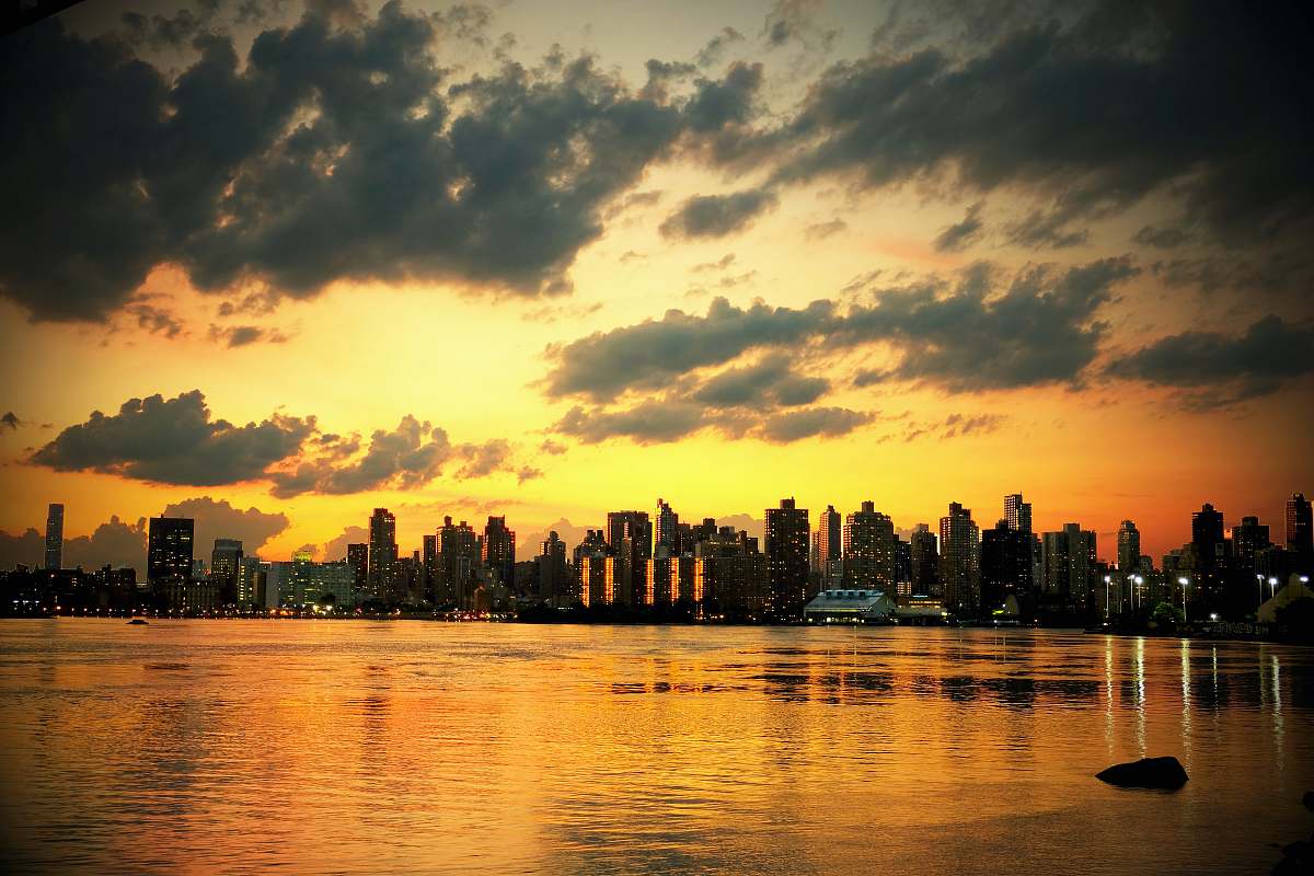 sunset photo of cityscape under white clouds during golden hours sky